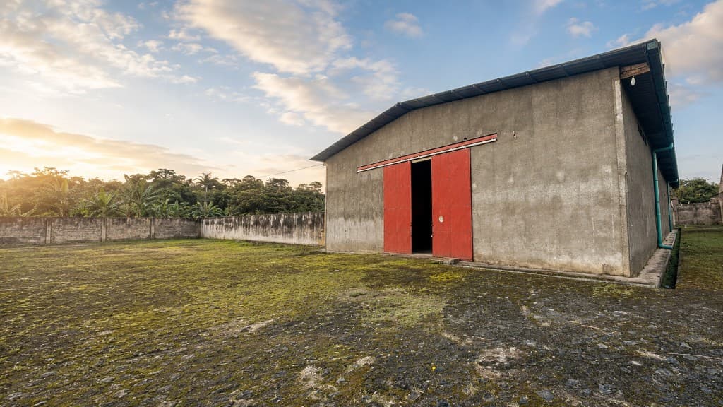 Facade of the SAMEN INDUSTRY plant and warehouse in Cameroon, red door at sunset